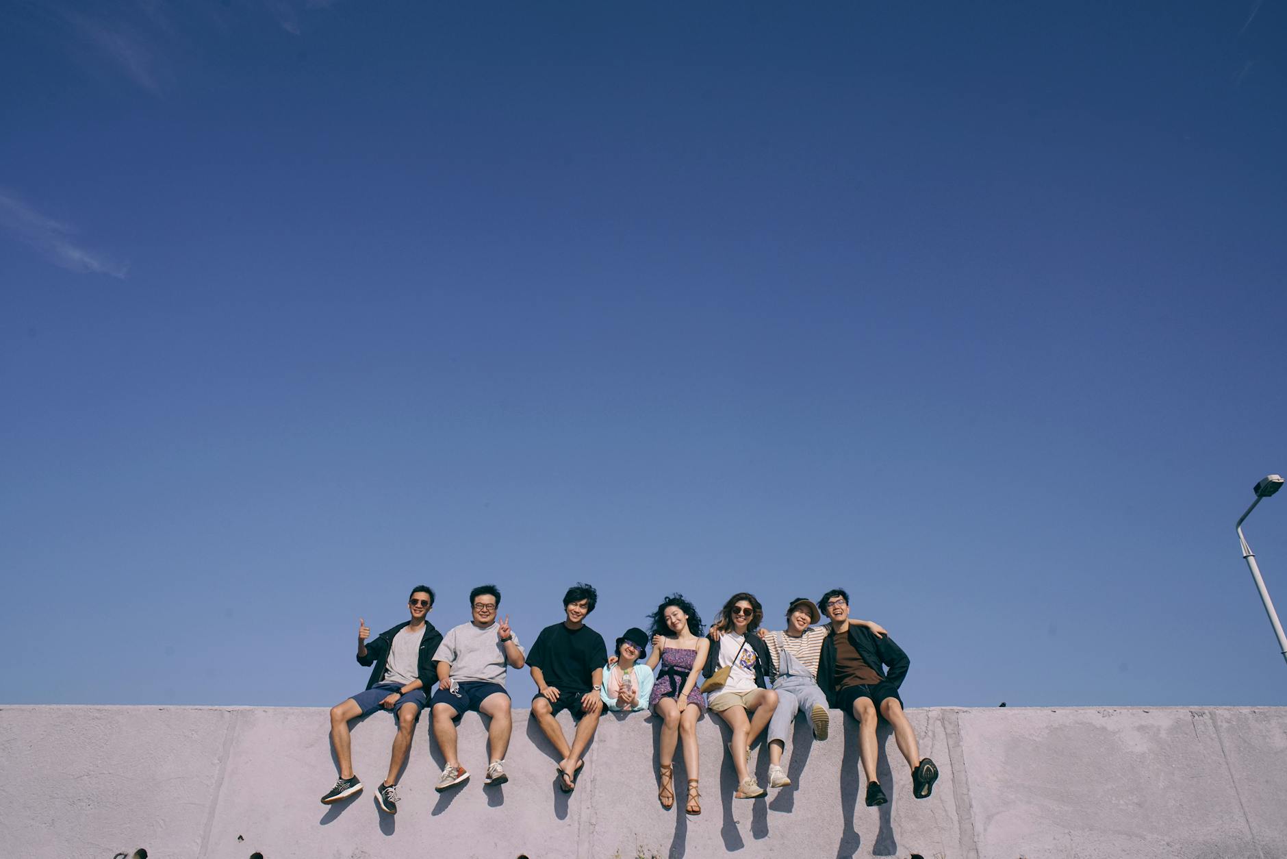 Group of diverse young travelers sitting around campfire sharing travel stories under starry Asian sky