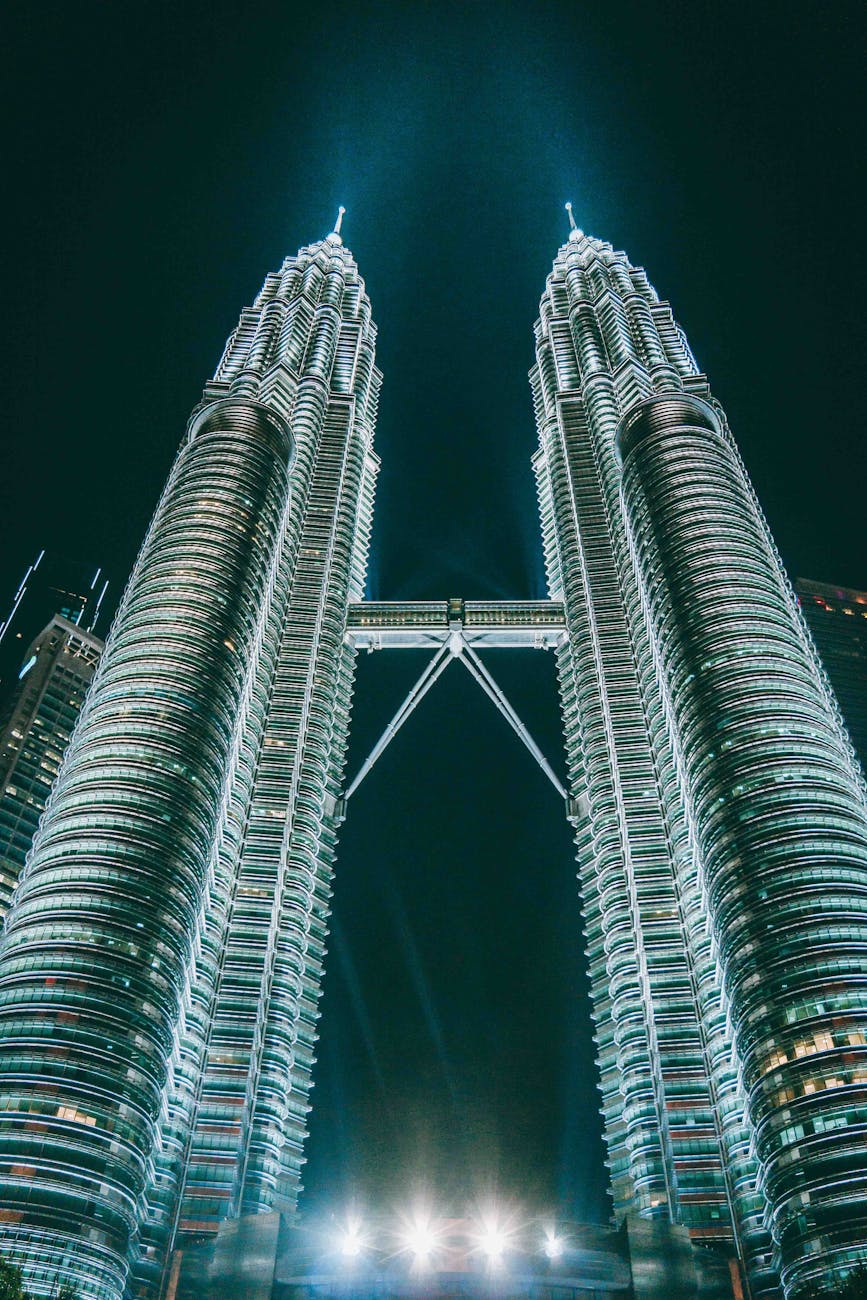 Iconic Petronas Twin Towers in Kuala Lumpur Malaysia illuminated at night with colorful fountain show