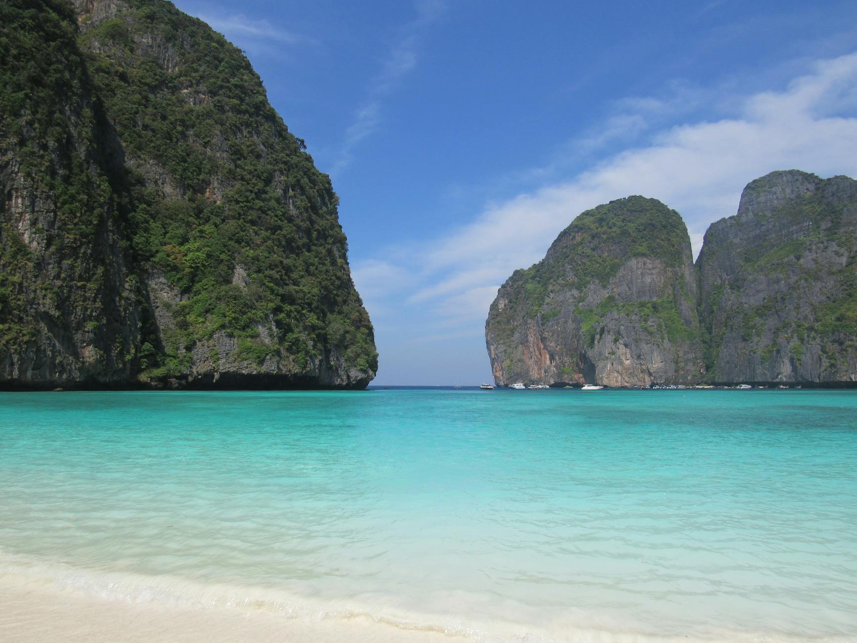 Stunning tropical beach in Krabi Thailand with crystal clear turquoise water and limestone cliffs at sunset